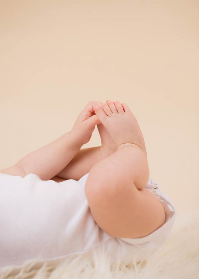 Babyfotos Berlin: Baby greift nach seinen nackten Füßen