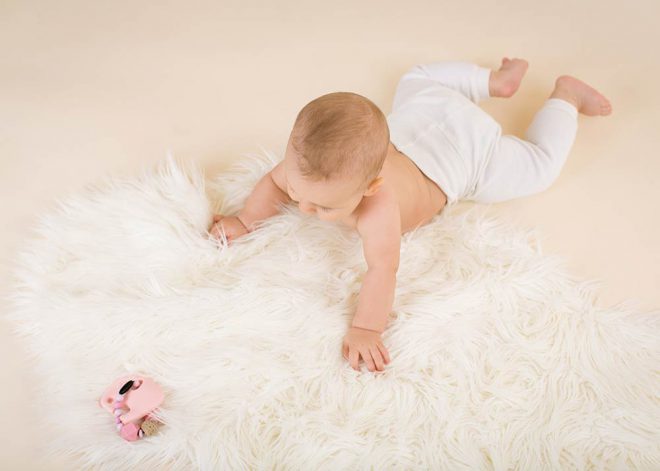 Babyfotos: Baby von oben schaut auf eine Rassel