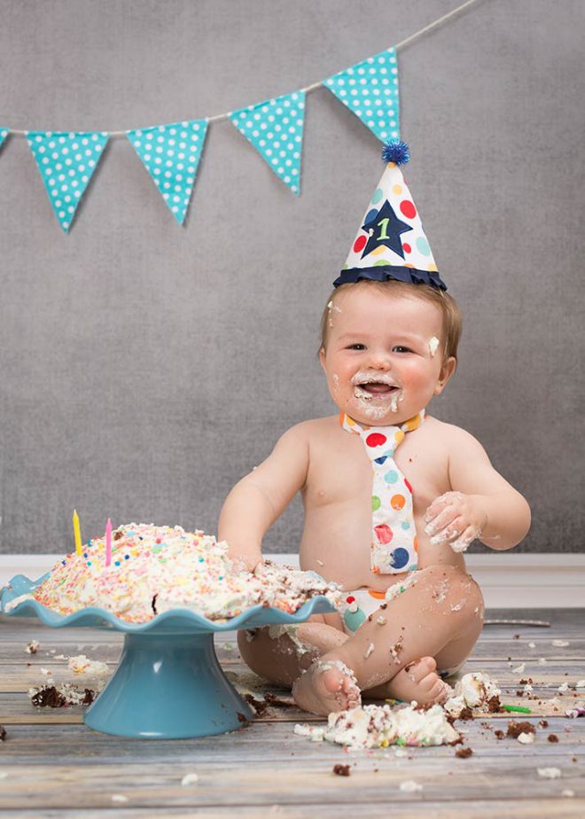 Cake Smash Fotos Berlin:Junge mit Partyhut und Krawatte feiert seinen 1. Geburtstag