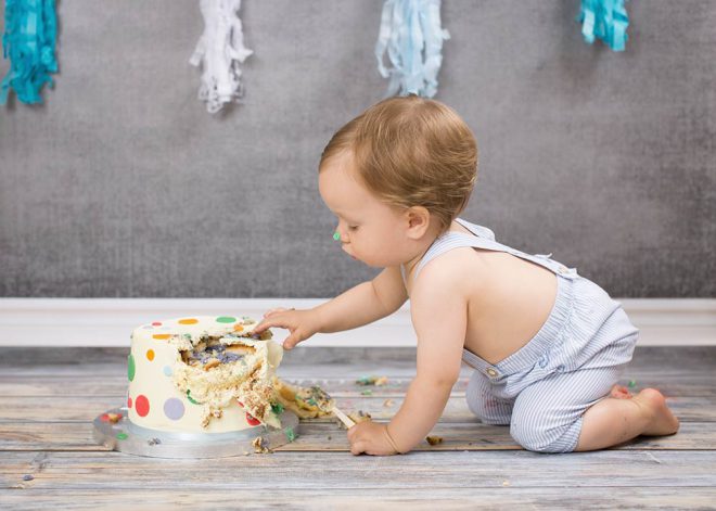 Junge in blauer Latzhose bekommt seine erste Torte geschenkt