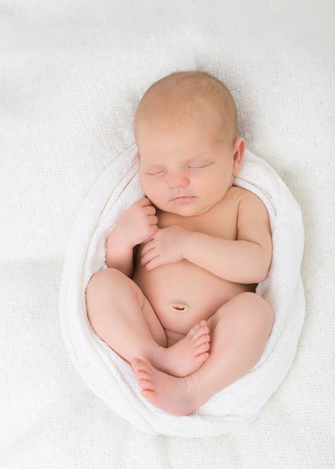 schlafendes Neugeborenes in weißem Tuch