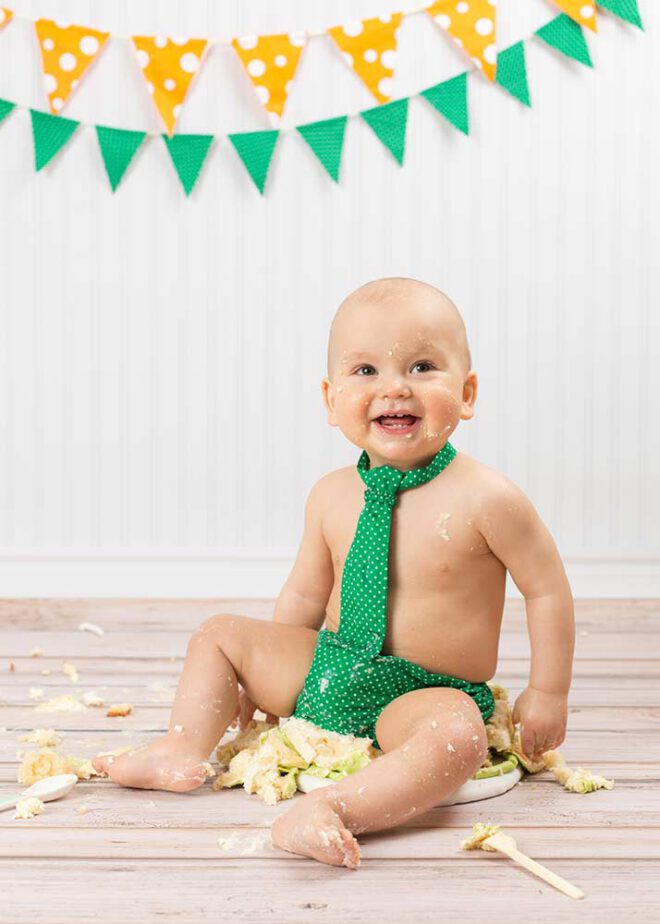 Cake Smash Shooting: Junge sitzt auf der Torte